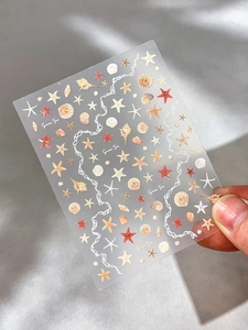 Detail view of pearlescent starfish and seashell nail stickers with summer time text