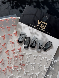Détail macro de stickers ongles nœuds 3D en relief avec perles et nail art scintillant