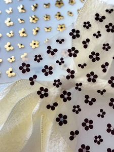 Detail view of golden hollow flower and purple 3D floral nail art sticker decals
