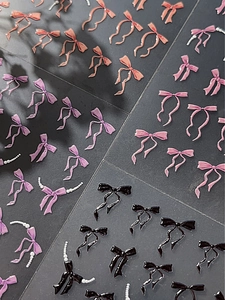 Vue détaillée de bijoux d'ongles en résine 3D en forme de nœuds avec perles roses