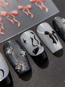 Gros plan sur les nœuds 3D et perles de nacre sur faux ongles style chic noir