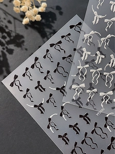 Détail de stickers nail art 3D en relief avec nuds de ruban et perles blanches