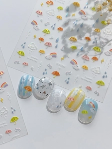 Macro detail of 3D embossed rainbow nail stickers with umbrellas and water droplets