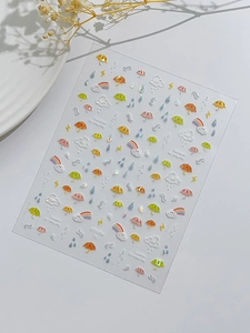 Detail shot of 3D embossed nail stickers featuring rainbow clouds and colorful raindrops