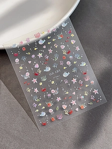 Gros plan sur des autocollants 3D pour ongles motif marin avec effet nacre brillante