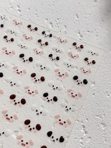 Macro shot of cute 3D cartoon animal face nail art stickers on a transparent sheet