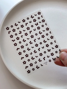 Detailed close-up of starlight five-petal flower nail stickers with silver dots