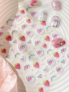 Detail view of strawberry and bow nail stickers with sweet heart patterns and glossy finish
