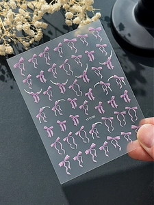 Gros plan détaillé des autocollants à ongles nœuds violets en relief 3D sur support