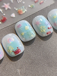 Vue macro d'autocollants nail art océan avec crabes et méduses de dessin animé et paillettes