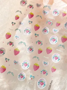 Close-up of strawberry and bow stickers on pink crinkled paper background for DIY crafts