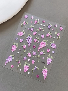 Detailed close-up of 5D embossed nail stickers featuring purple grape and flower patterns