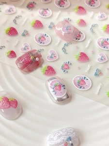 Macro shot of strawberry and bow nail stickers with 3D embossed heart patterns