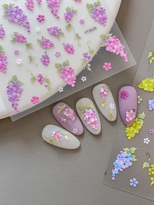 Macro detail of 5D embossed nail stickers featuring purple grapes and floral designs