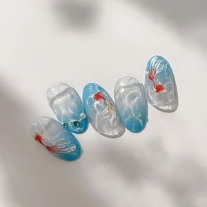 Nail art stickers with blue gradient koi fish designs and pearl rhinestone accents