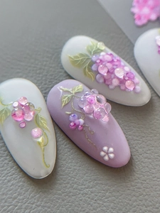 Macro detail of 3D embossed grape and floral patterns on lilac press-on nails