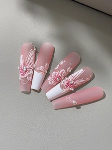 Detail of 3D embossed pink gradient nail stickers with white floral and butterfly patterns