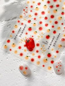 Detailed view of tomato nail stickers with hand-painted patterns on natural stone