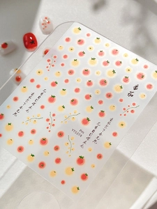 Detail view of tomato pattern nail stickers with red fruit illustrations and leaf accents