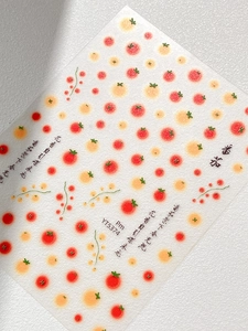 Macro detail of tomato pattern nail stickers with artistic Chinese calligraphy