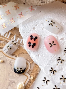 Autocollant d'art d'ongle avec nœud 3D noir et perles sur dégradé de rose