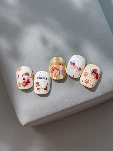 Close-up of cute cartoon puppy nail stickers with heart and plaid patterns on gray texture
