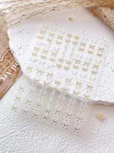 Détails des autocollants pour ongles avec nœuds blancs, bordure dorée et dentelle