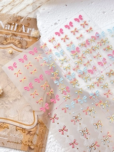 Détails d'autocollants 3D pour ongles avec nœuds roses et bleus et texture dorée gaufrée