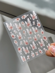 Close-up of 5D embossed nail stickers featuring elegant floral and butterfly patterns