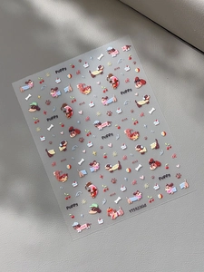 Close-up of cute cartoon dachshund and cherry nail art stickers on textured background