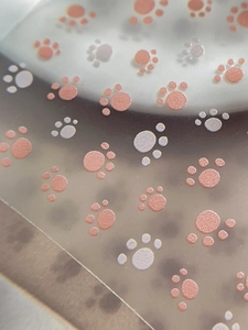 Macro shot of glittery cat paw nail stickers with rose gold and pearly white finishes