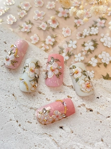Detail of 3D embossed cherry blossom nail stickers with pearls and gold outlines