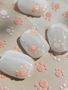Macro shot of short round press-on nails with 3D embossed pink cat paw design