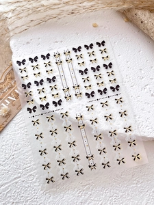 Détail macro d'autocollants pour ongles nœuds noir et or avec motifs à pois élégants