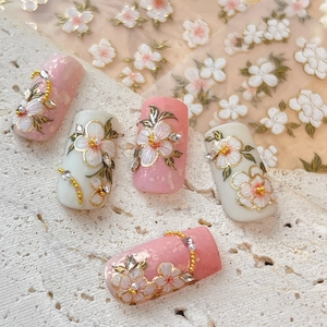 Elegant floral nail stickers featuring pink and white embossed flowers with gold edges