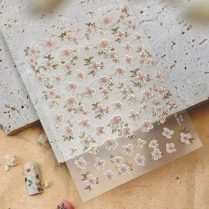 Pink cherry blossom nail art stickers with gold edges and petal designs for manicure