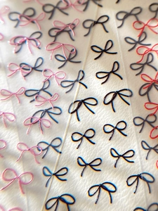 Detailed macro view of 3D embossed bow nail stickers in black, red, and pink colors