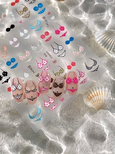 Détail de stickers nail art bikini avec motifs léopard et pois sur ongles transparents