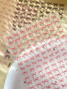 Macro detail of 3D embossed bow nail art stickers in red, black and pink colors