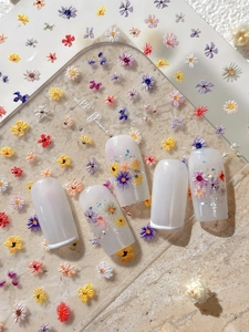 Macro view of embossed floral nail stickers featuring colorful 3D mini flower patterns