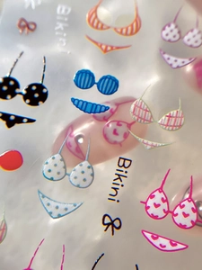 Vue macro de stickers nail art bikini avec motifs de maillots de bain colorés