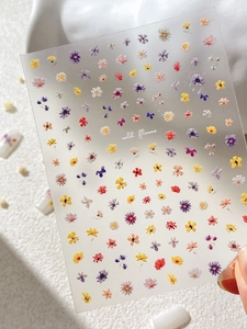 Detailed view of colorful embossed 3D flower nail art stickers with wild flower text