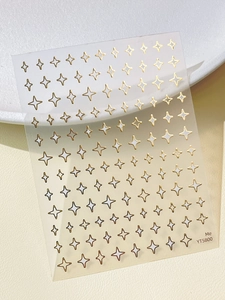 Macro shot of YT5800 gold foil star nail art stickers on a minimalist white background