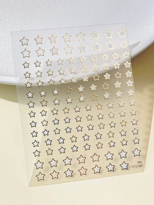 Detail showing gold-stamped star nail art stickers on a premium textured background