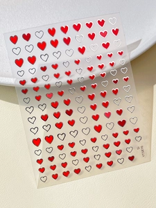 Close-up of red and silver heart nail art stickers with metallic gold stars finish