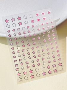 Macro shot of pink and black star nail stickers on a transparent sheet for DIY manicure