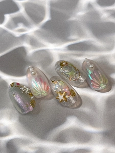Detailed view of mermaid style nail stickers with pearls and golden starfish decorations