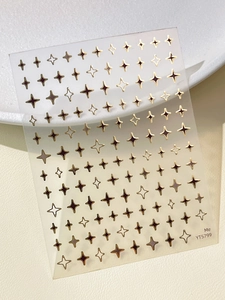 Macro detail of metallic gold star nail art stickers with various sizes and shiny finishes
