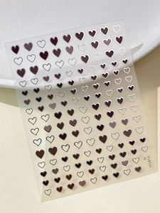 Macro shot of YT5814 heart-shaped nail art stickers on beige leather texture