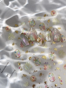 Macro view of 3D ocean-themed nail art stickers with shells, stars and laser pearl texture